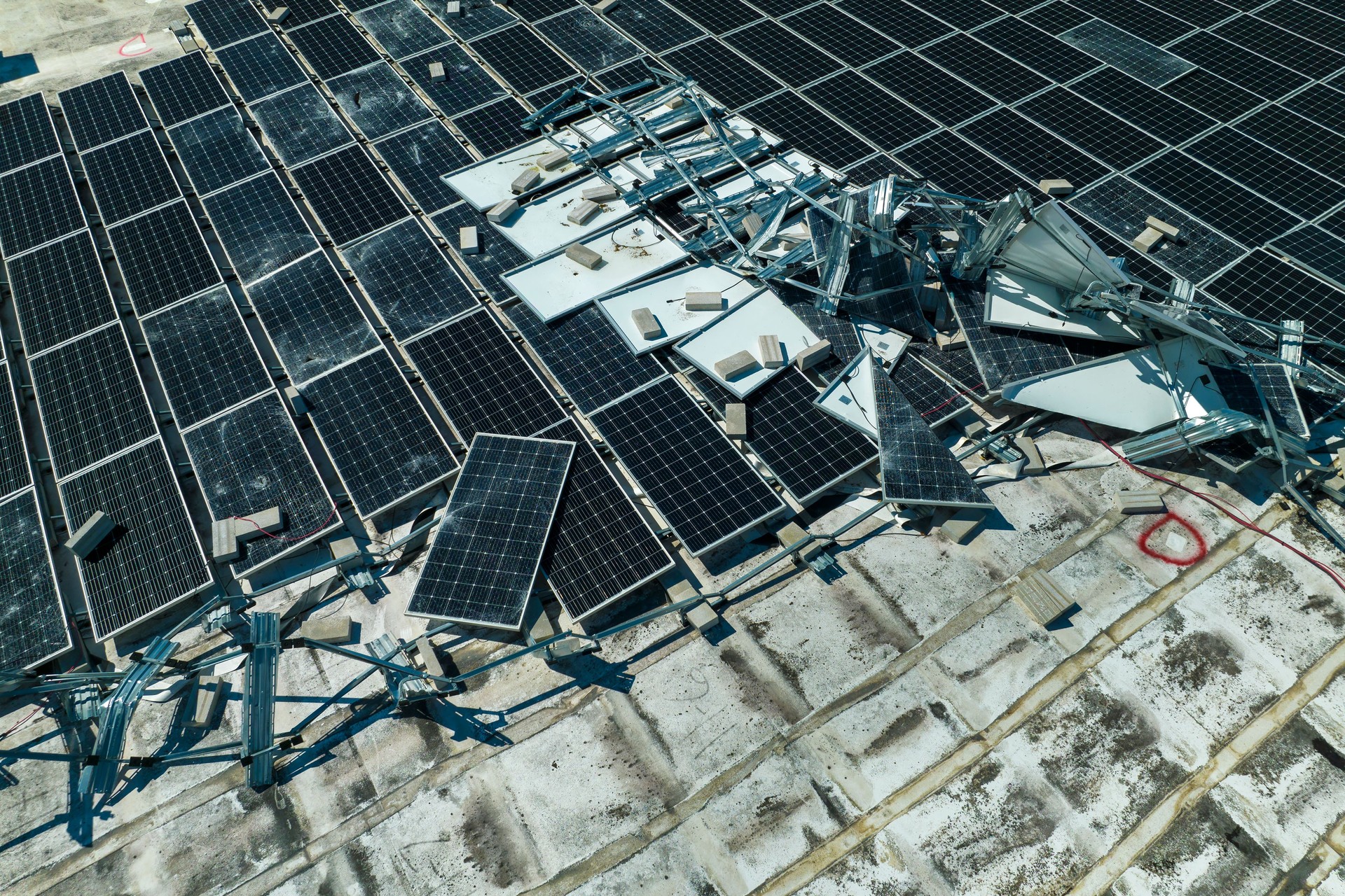 Consequences of natural disaster. Damaged by hurricane wind photovoltaic solar panels mounted on industrial building roof for producing green ecological electricity